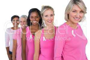 Group of diverse women wearing pink tops and ribbons for breast