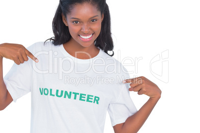 Smiling young woman wearing volunteer tshirt and pointing to it
