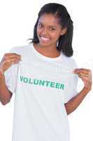 Young woman wearing volunteer tshirt and pointing to it