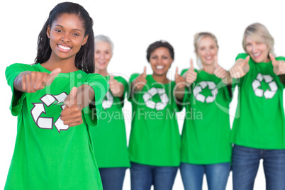 Team of female environmental activists smiling at camera and giv