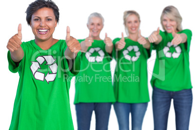 Happy women wearing green recycling tshirts giving thumbs up