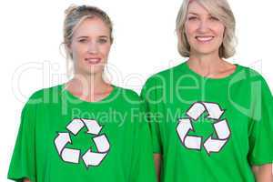 Two women wearing green recycling tshirts