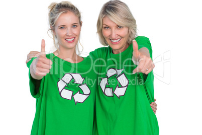 Two smiling women wearing green recycling tshirts giving thumbs