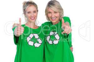 Two smiling women wearing green recycling tshirts giving thumbs