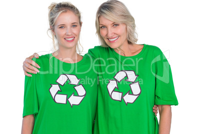 Two smiling women wearing green recycling tshirts