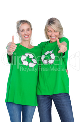 Two women wearing green recycling tshirts giving thumbs up