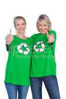 Two women wearing green recycling tshirts giving thumbs up