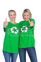 Two blonde women wearing green recycling tshirts giving thumbs u