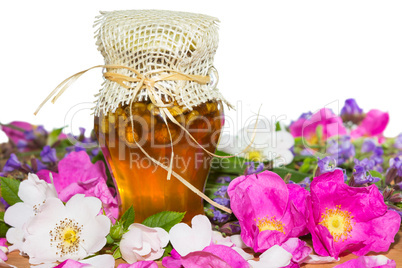 Honey jar with blossoms and herbs