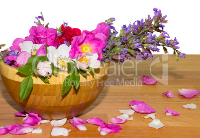 Wooden bowl with dog roses and sage flowers