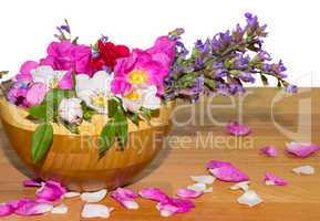 Wooden bowl with dog roses and sage flowers