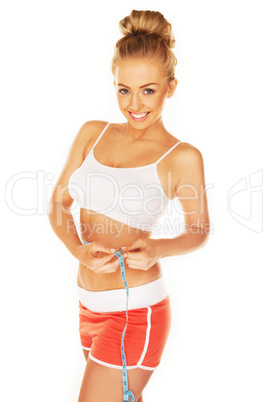 attractive athletic woman measuring her waist