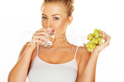 woman drinking water and eating grapes