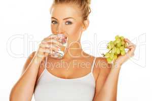 woman drinking water and eating grapes