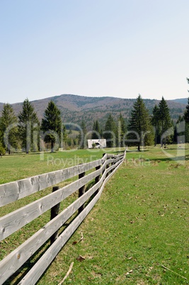 Wooden fence on mountain green meadow
