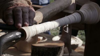 craftsman turning wood on a vintage lathe