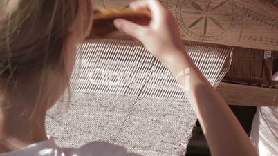 girl working with traditional loom