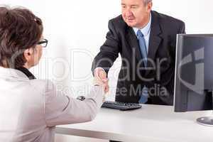 Businessman in office ranges woman's hand