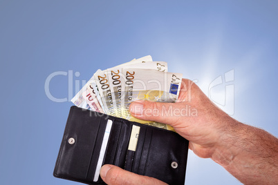Hand with banknotes and wallet