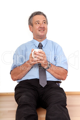 Man with cup sitting on the floor