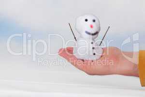 Hand holding small snowman