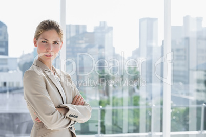 Blonde businesswoman standing with arms crossed