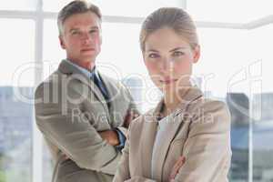 Serious business people standing with their arms crossed
