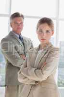 Serious business people standing with arms crossed