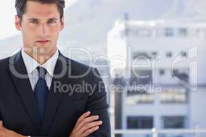 Handsome businessman standing with arms folded
