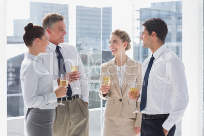 Group of cheerful business people clinking their flutes of champ