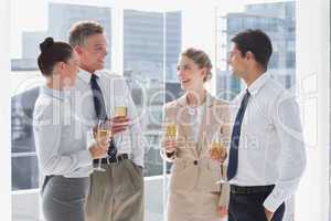 Group of cheerful business people clinking their flutes of champ