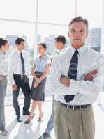 Boss standing with arms folded in a modern office