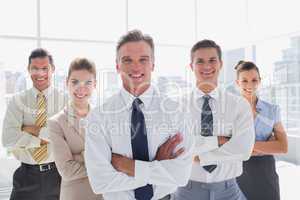 Smiling business people with arms crossed in their office