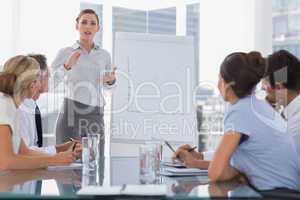 Businesswoman giving explication in front of a growing chart
