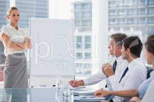 Businesswoman with arms folded in front of colleagues