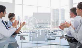 Business people applauding at a blank whiteboard