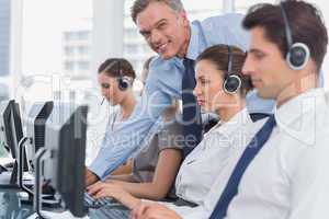 Smiling manager helping call centre employee