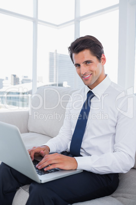 Smiling business man using laptop