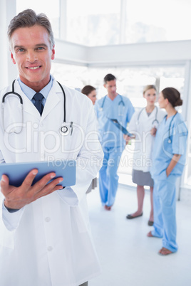 Cheerful doctor holding digital tablet