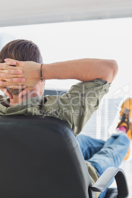 Rear view of a designer relaxing in a modern office