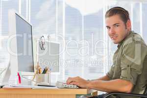 Smiling creative business employee working on computer