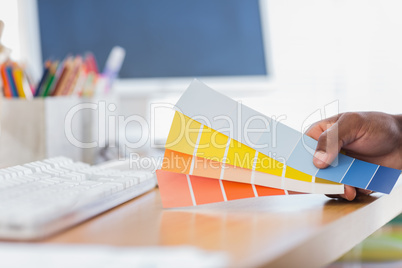 Hand holding colour charts in a modern office