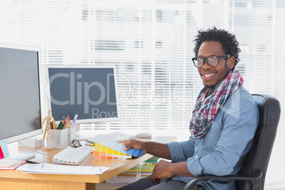 Smiling interior designer holding colour charts