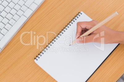 Hand of woman drawing on a paper on a desk