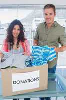 Volunteers taking out clothes from a donation box