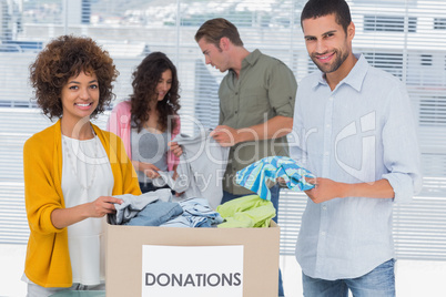 Team of volunteers taking out clothes from a donation box