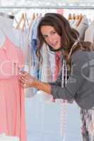 Fashion designer picking needles in a dress