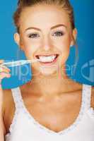 happy blonde woman brushing her teeth