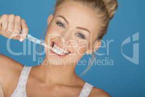 happy blonde woman brushing her teeth