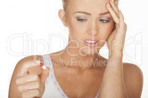 blonde woman holding a pill